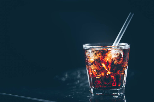 Кубинский либр коктейль у барной стойки. Темный фон. Горизонталь
 - Фото, изображение