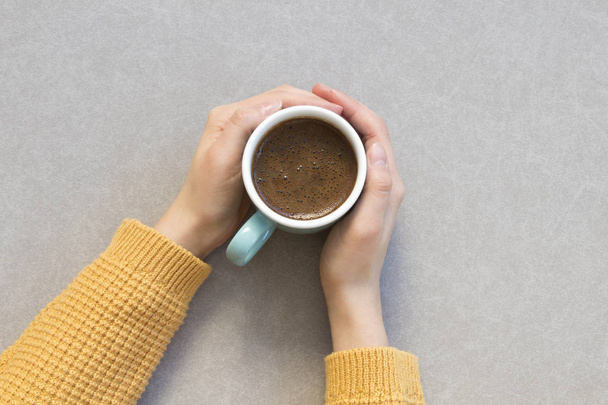 γυναίκα χέρι που κρατά το φλιτζάνι του καφέ σε γκρι φόντο - Φωτογραφία, εικόνα