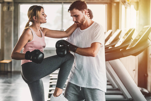 Mujer y hombres deportivos con los guantes de boxeo de espalda entrenando en el gimnasio
 - Foto, Imagen