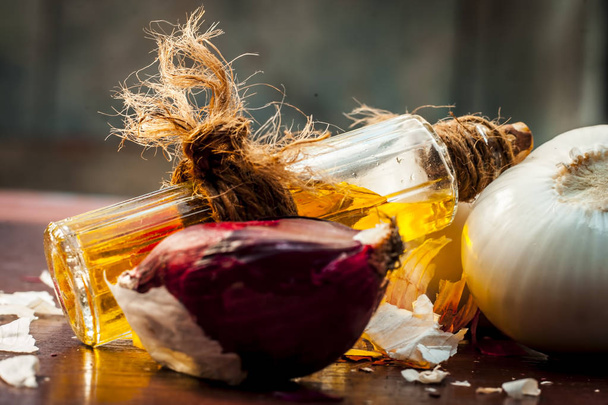 Close up of onions and oil and on wooden table - Фото, зображення