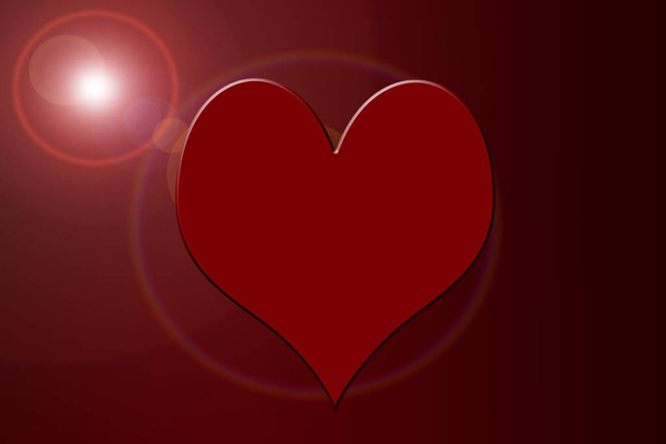 A heart shape in a red gradient with a sun or lens flair. - Valokuva, kuva