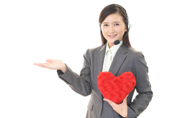 Operador de centro de llamadas sonriente con un corazón rojo
 - Foto, imagen