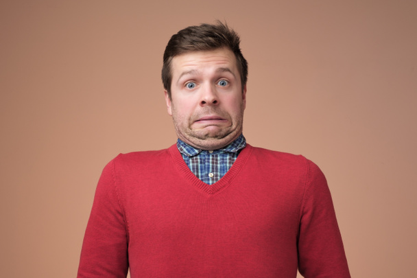 Funny caucasian man grimacing guilty face at studio background - Photo, Image