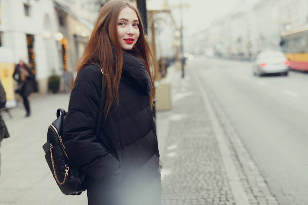 Pretty girl wait for her bus on the city street with copy space. - Image - 写真・画像