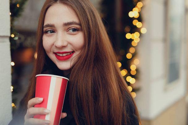 Woman Drink Her Hot Coffee While Walking On The Street. Portrait Of Stylish Smiling Woman In Winter Clothes Drinking Hot Coffee. Female Winter Style. - Image - Foto, Imagem