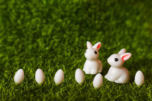 two rabbits and eggs on the grass. close-up figures - Photo, image