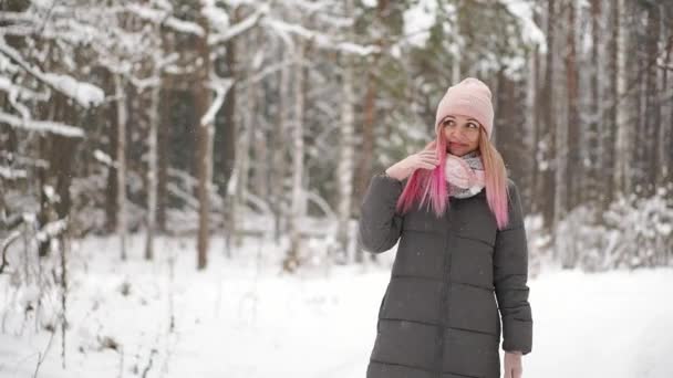 Gelukkig mooie vrouw in casual stijl Oprollen met haar handen terwijl het sneeuwt op het mooie dorpsplein in de winter. Buiten. Portret shot - Video