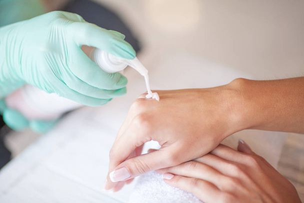 Woman Hand Care. Applying Peeling Scrub or Moisturizing Cream on to the Hands - Foto, afbeelding