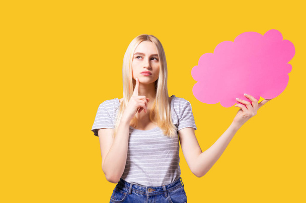 Young beautiful woman wearing white t-shirt and mom jeans, holding blank speech bubble with copy space for text. Attractive blonde female with empty message box. Grey isolated background. - Photo, image