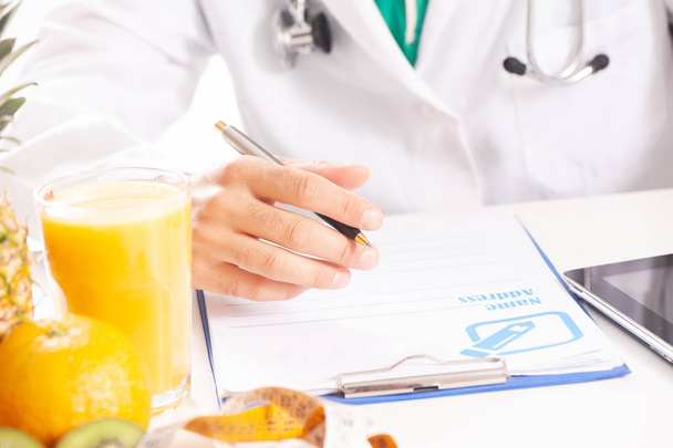 Nutritionist doctor writing diet plan on table. - Photo, Image