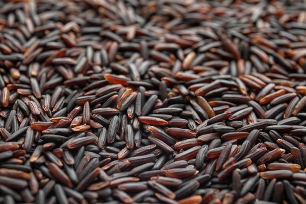 Pile of uncooked black rice as background, closeup - Photo, Image