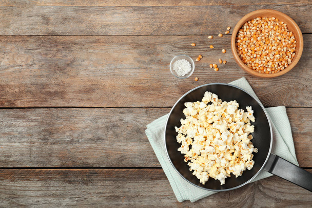 Composition with popcorn and space for text on wooden table, flat lay - Foto, immagini