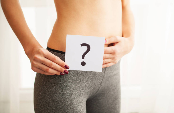 Gesundheit. Frauenkörper in Unterwäsche mit Fragezeichen am Bauch - Foto, Bild