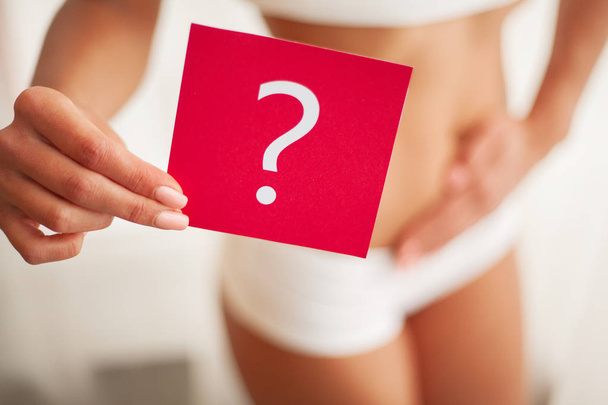 Salud. Mujer cuerpo en ropa interior con tarjeta de preguntas cerca del vientre
 - Foto, Imagen