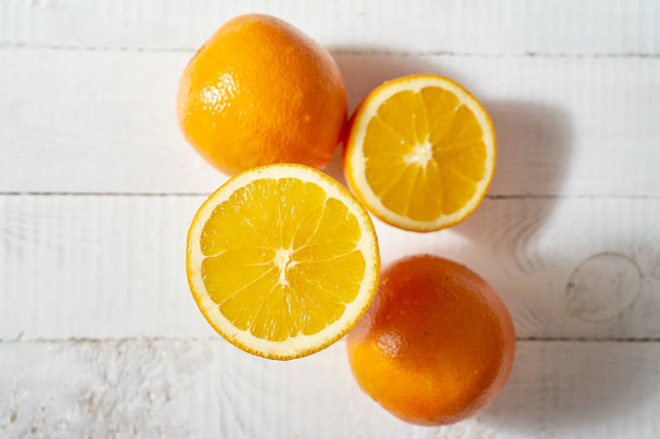 Top remek kilátás a szerves narancssárga gyümölcs a régi fehér fából készült asztal. - Fotó, kép