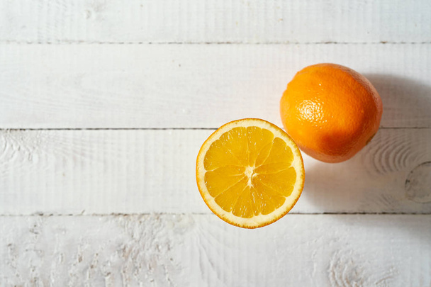 Top remek kilátás a szerves narancssárga gyümölcs a régi fehér fából készült asztal. - Fotó, kép