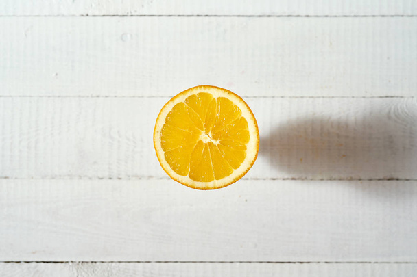Vista superior de fruta orgánica mitad naranja en la vieja mesa de madera blanca
. - Foto, imagen