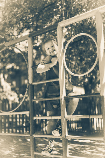 Aranyos kislány a játszótéren, a nyáron. Fekete-fehér régi stílusú fotó. - Fotó, kép