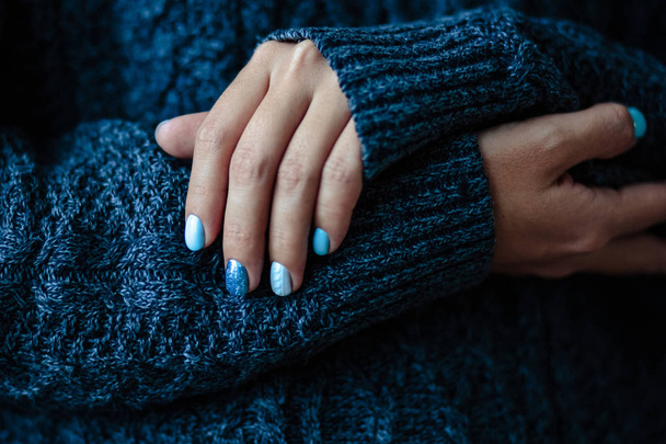 Gorgeous manicure, pastel tender blue color nail polish, closeup photo. Female hands over simple background - Фото, изображение