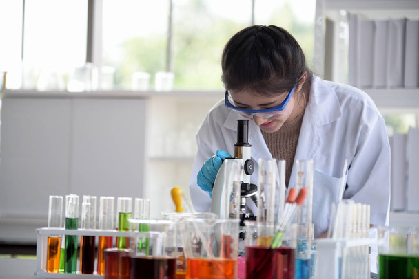 若手研究者と科学アジアの科学者が研究室で試験管を保持で実験しています。科学者は、科学研究所で働いています。研究室と研究室 Equipment.microbiological 分析、医学. - 写真・画像