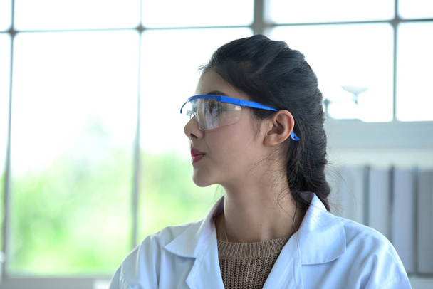 De jeunes scientifiques expérimentent la science chez un scientifique asiatique tenant une éprouvette dans un laboratoire. Les scientifiques travaillent dans les laboratoires scientifiques
.  - Photo, image