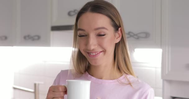 Young woman in pink t-thirt enjoy drinking tea with winter cookie at home - Záběry, video