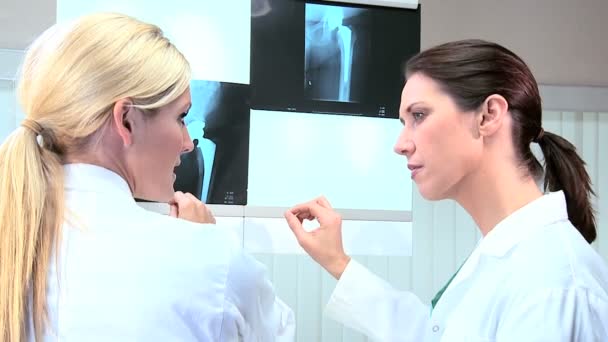 Técnicas femeninas examinando escáneres de rayos X
 - Metraje, vídeo