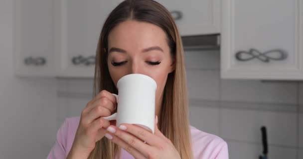 Young woman in pink t-thirt enjoy drinking tea with winter cookie at home - Video, Çekim