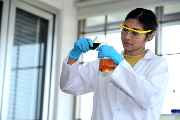 Mladí vědci experimentují s vědou na asijské vědec drží zkumavky v laboratoři. Vědci pracují ve vědecké laboratoře.  - Fotografie, Obrázek