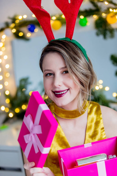 donna in corna di renna di Natale e confezione regalo
 - Foto, immagini