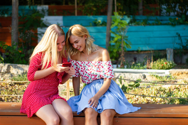 due amici si divertono nel parco, usano uno smartphone
 - Foto, immagini
