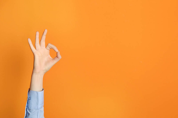 Young woman showing OK gesture on color background. Space for text - Фото, зображення