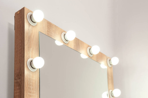 Mirror with light bulbs on white wall, closeup. Dressing room - Fotografie, Obrázek