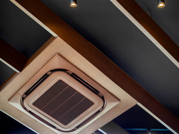 Moderne bruin plafond cassette type airconditioner met Led track licht op moderne design plafond gemonteerd. - Foto, afbeelding
