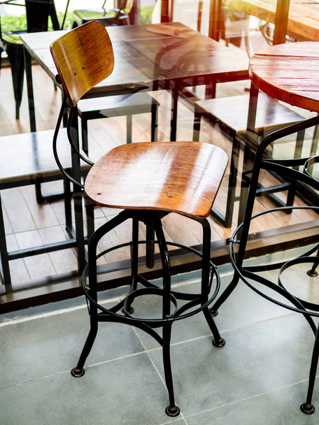 Vintage Barhocker aus Holz mit Beinen aus schwarzem Stahl im vertikalen Stil des Cafés. - Foto, Bild
