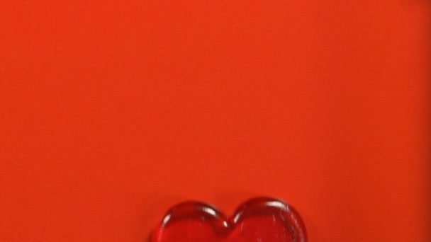 Szív alakú nyalókát piros háttér, a Valentin-nap-szimbólum, a topview elszigetelt - Felvétel, videó
