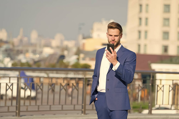 Businessman with smartphone on sunny terrace. Man in business suit with mobile phone outdoor. Business communication, new technology and sms. Modern life and business lifestyle - Фото, зображення