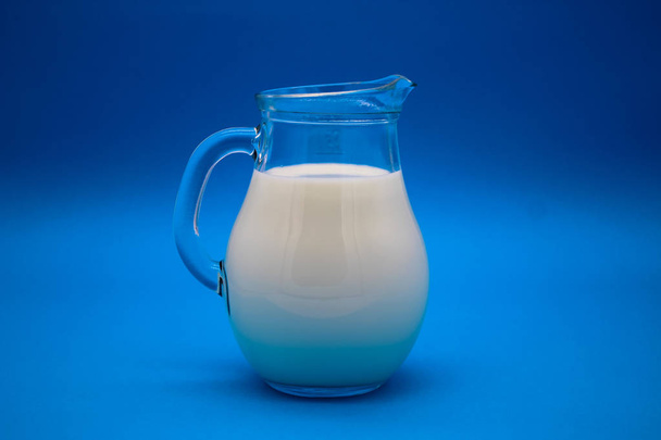 Egy korsó tej kék háttérrel - Fotó, kép