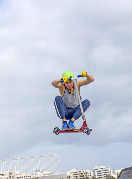 Teini-ikäinen poika hyppää luistelupuistossa rampin yli
 - Valokuva, kuva