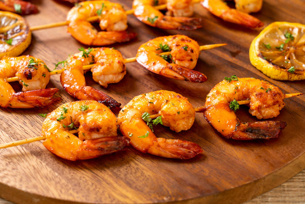 Grilled tiger shrimps skewers with lemon - seafood style - 写真・画像