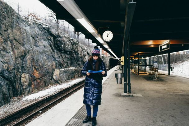 Young tourist woman looking at metro map while standing on platform at Stockholm subway - Zdjęcie, obraz