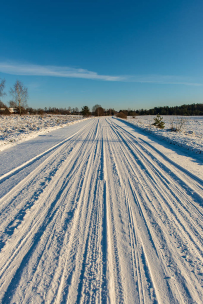 snow covered winter road with tire tracks - Photo, Image
