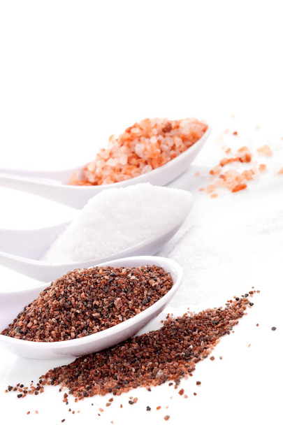Himalayan and kitchen salts in spoons isolated on white bckground. - Zdjęcie, obraz