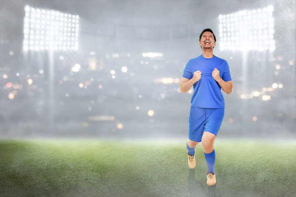 Felice giocatore di calcio asiatico celebrare i suoi obiettivi nella partita
 - Foto, immagini