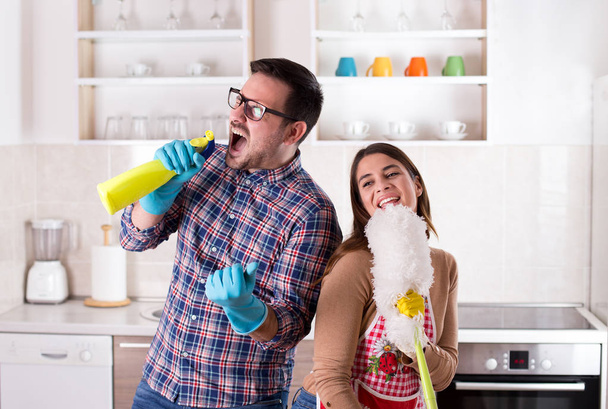 Şarkı ve having fun ev işleri yaparak mutlu genç çift - Fotoğraf, Görsel