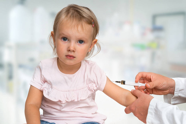 Lastenlääkäri ruiskuttaa rokotteen olkapäähän - rokotuskonsepti - Valokuva, kuva