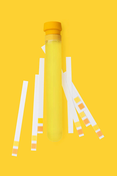 Biohacking の背景。テスト チューブと ph の尿は、黄色の背景のストリップをテストします。バイオテック - 写真・画像