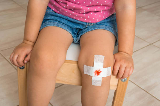 子供膝の傷害の概念上の血付け絆創膏 - 写真・画像