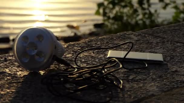 Metallic microphone and a mobile lie on a riverbank - Footage, Video