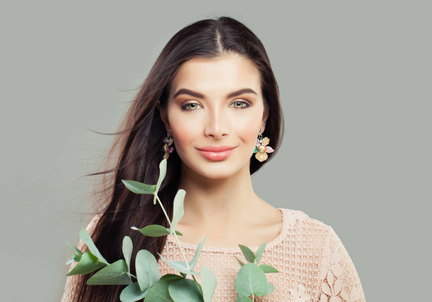 Mulher bonita jovem sorrindo e segurando folhas verdes galho
 - Foto, Imagem